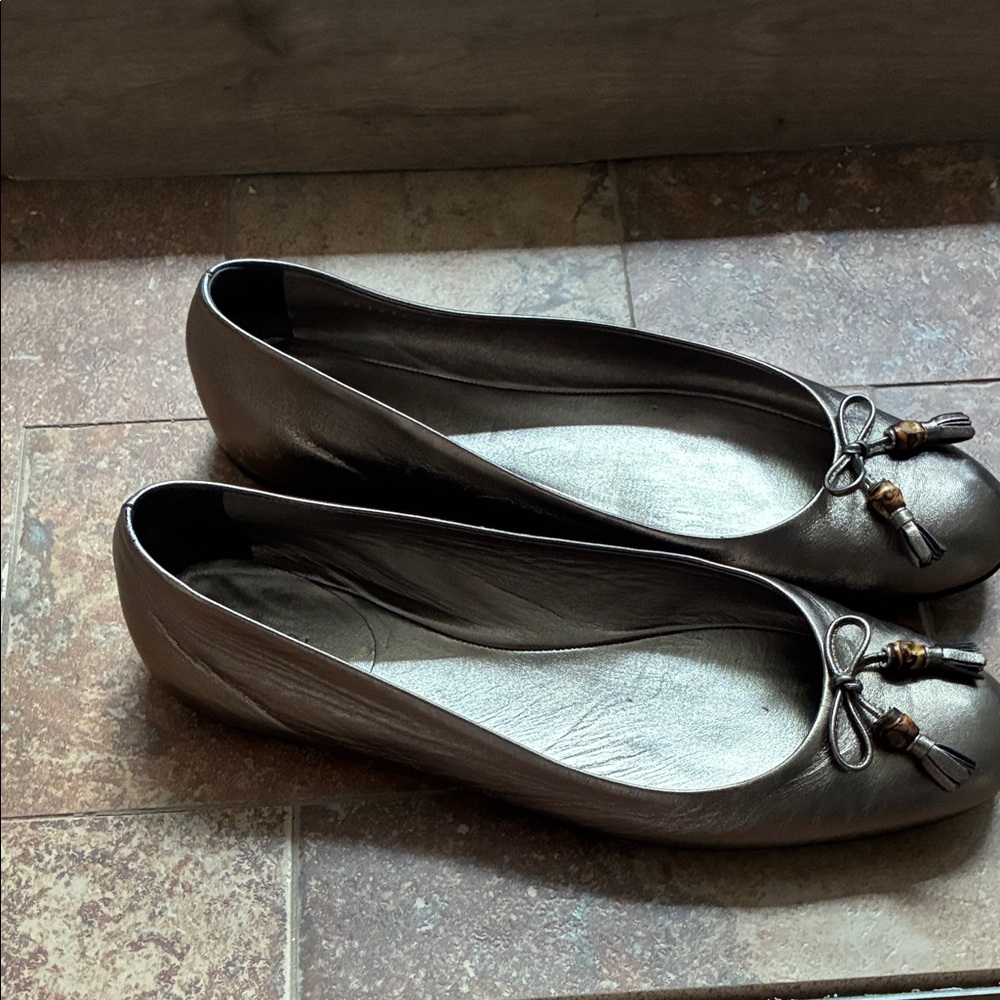 Gucci Metallic Bronze Flats with Tassels. Small discoloration on left back heel.